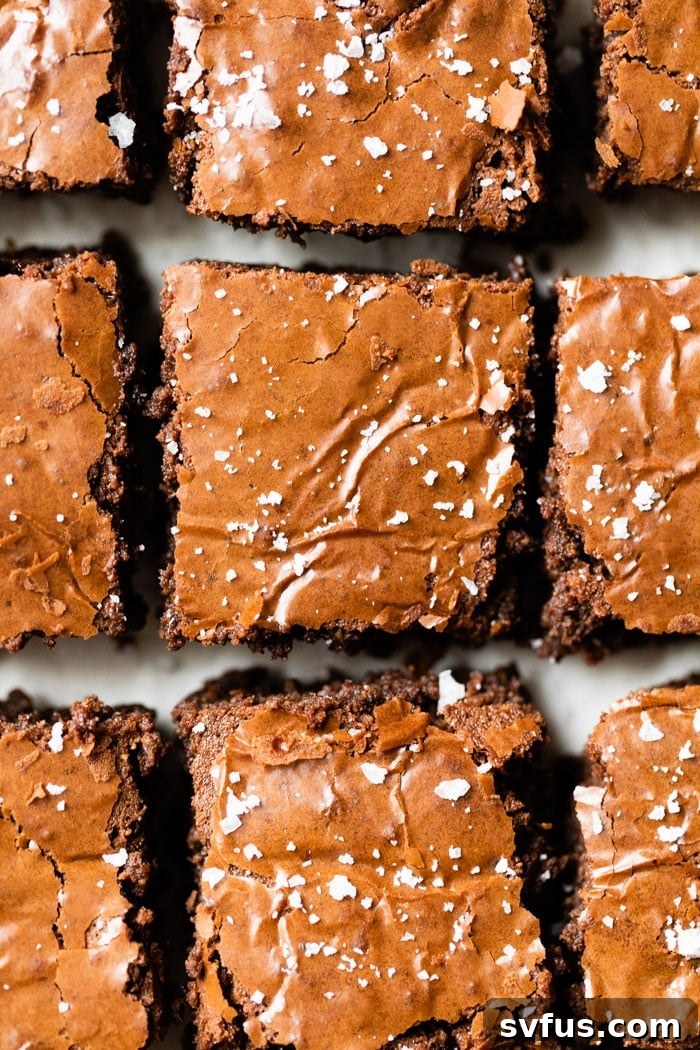 Rich, fudgy paleo brownies with crackly tops and a sprinkle of sea salt, invitingly arranged
