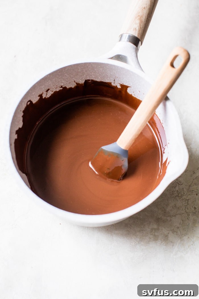 Close-up shot of perfectly smooth, melted chocolate and coconut oil in a saucepan, ready for brownie batter