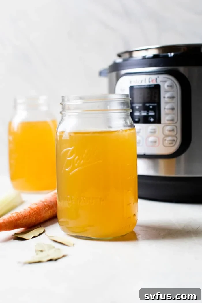 A glass jar filled with golden, homemade Instant Pot bone broth, ready to be enjoyed or stored.