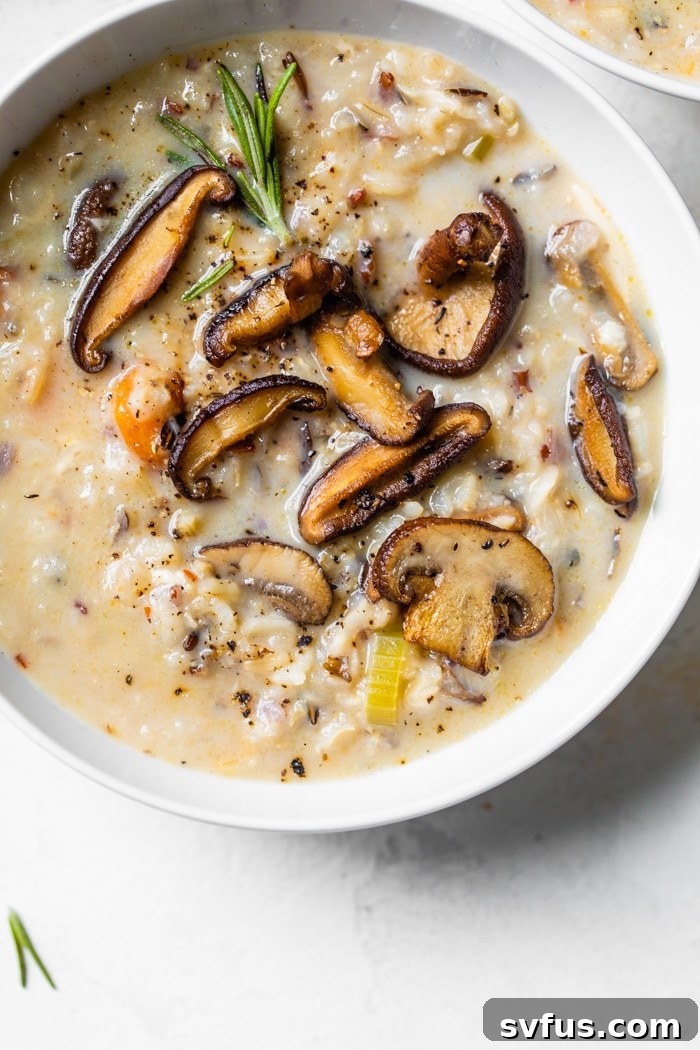 A steaming bowl of Instant Pot Wild Rice Soup topped with sautéed mushrooms and a sprinkle of Parmesan cheese, a gluten-free and meatless delight.