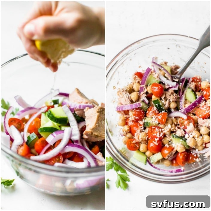 A close-up view of the Mediterranean Chickpea Tuna Salad being dressed with a generous squeeze of fresh lemon juice, highlighting the vibrant colors and readiness of the dish.