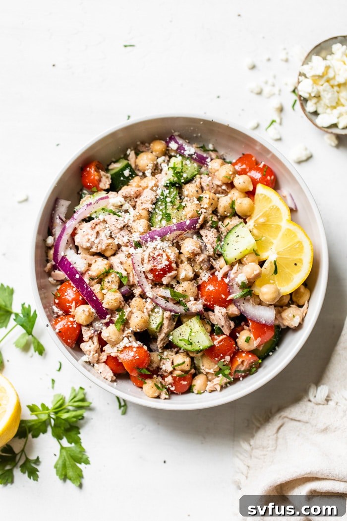 A large, inviting bowl of Mediterranean Chickpea Tuna Salad, showcasing the abundant chickpeas, flaked tuna, diced vegetables, and fresh herbs, ready to be served.