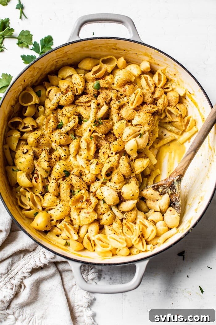 Creamy vegan mac and cheese in a skillet, topped with charred breadcrumbs