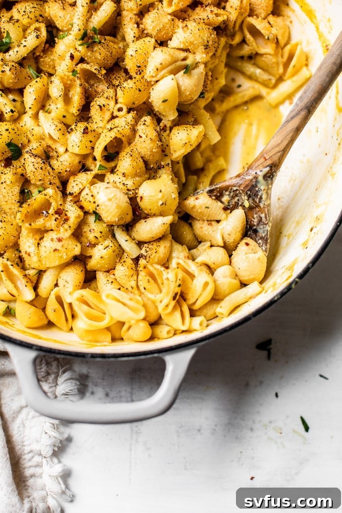 Pasta covered in creamy vegan cheese sauce in a skillet