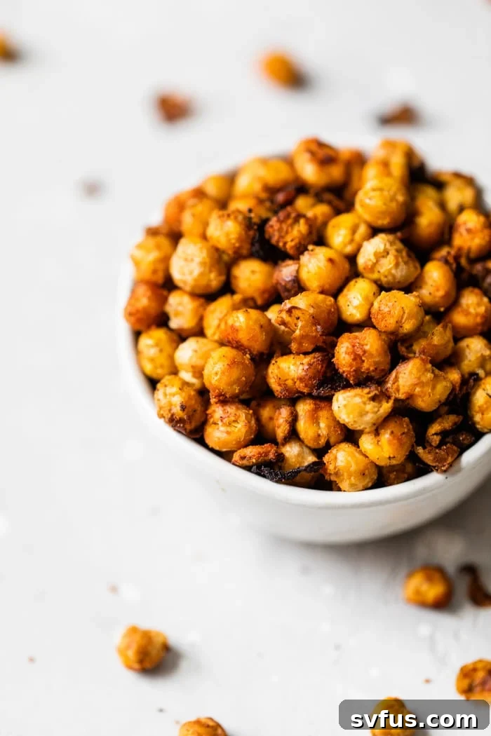 A bowl of perfectly seasoned, golden-brown crunchy roasted chickpeas, ready to be enjoyed as a healthy snack or topping.