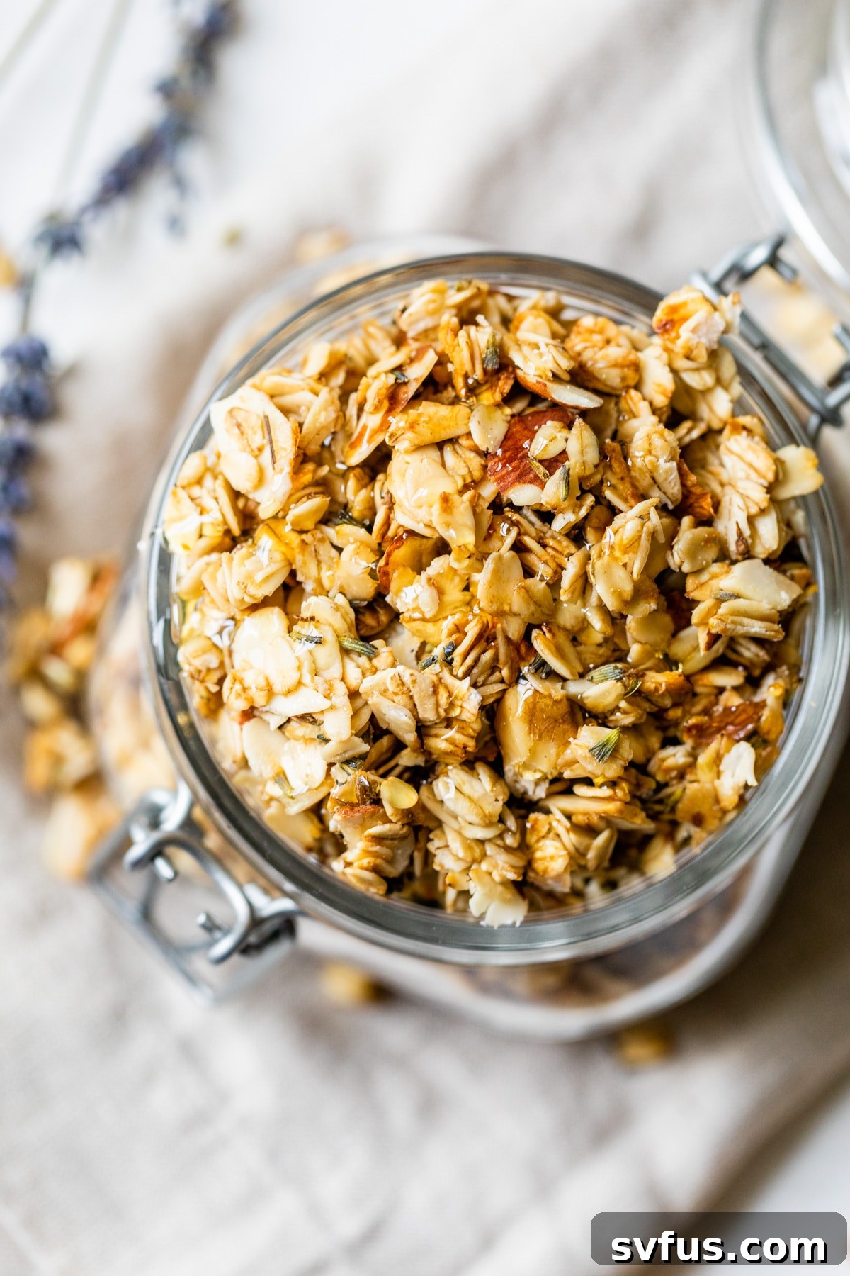 Close-up of freshly baked lavender granola stored in a transparent glass jar