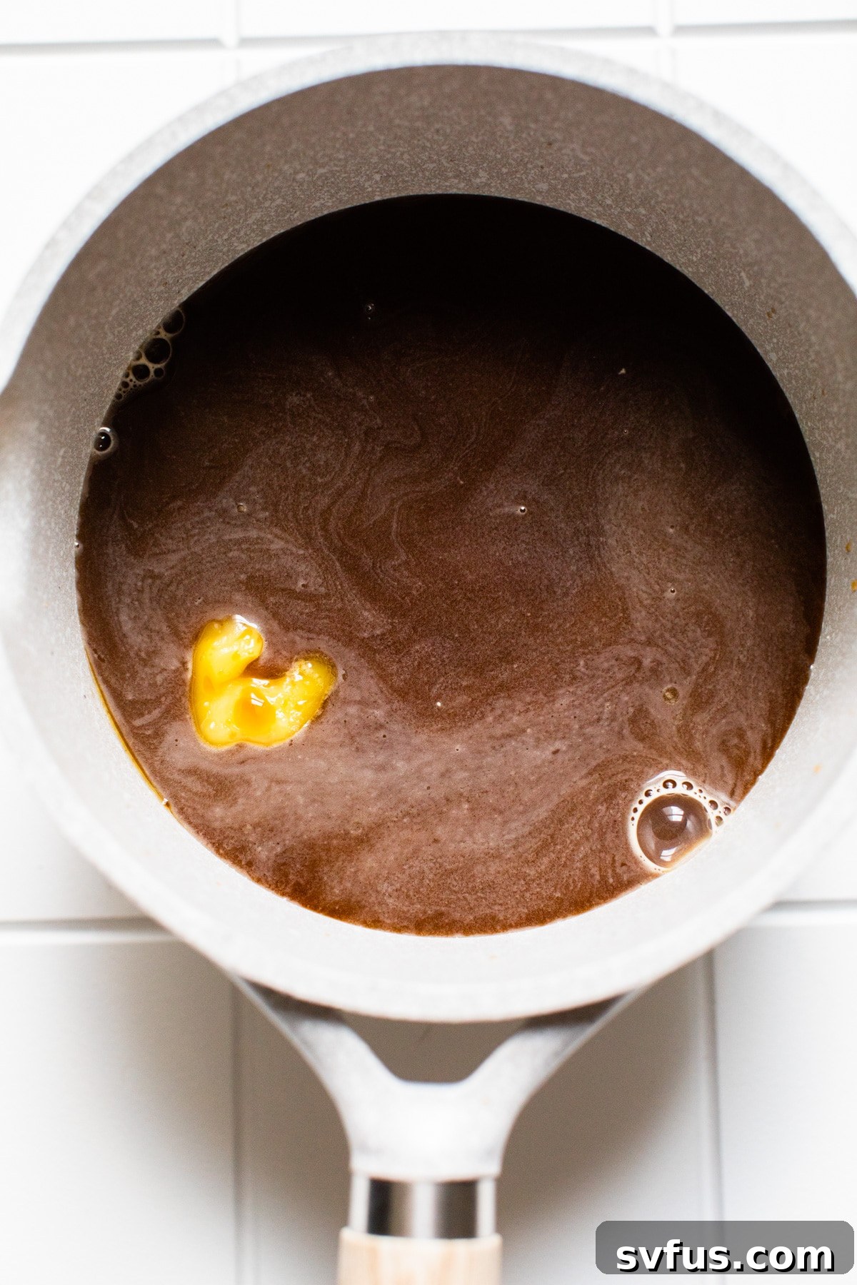 Cold brew, ghee, and collagen gently heating in a saucepan