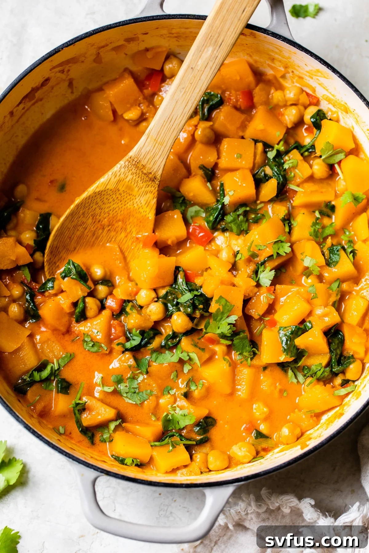 Butternut squash and chickpeas simmering in a skillet, ready to be served as a comforting curry dish.