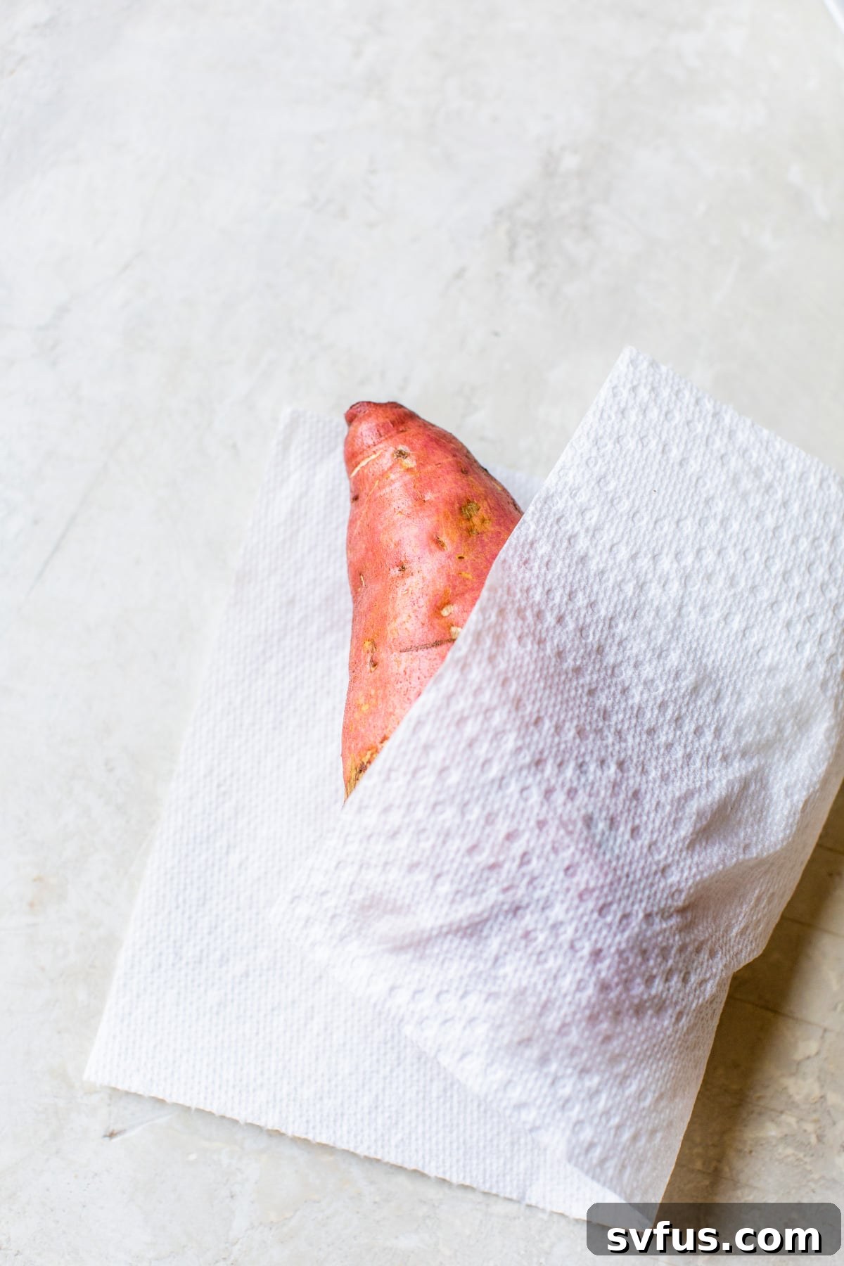 sweet potato being wiped dry with a paper towel