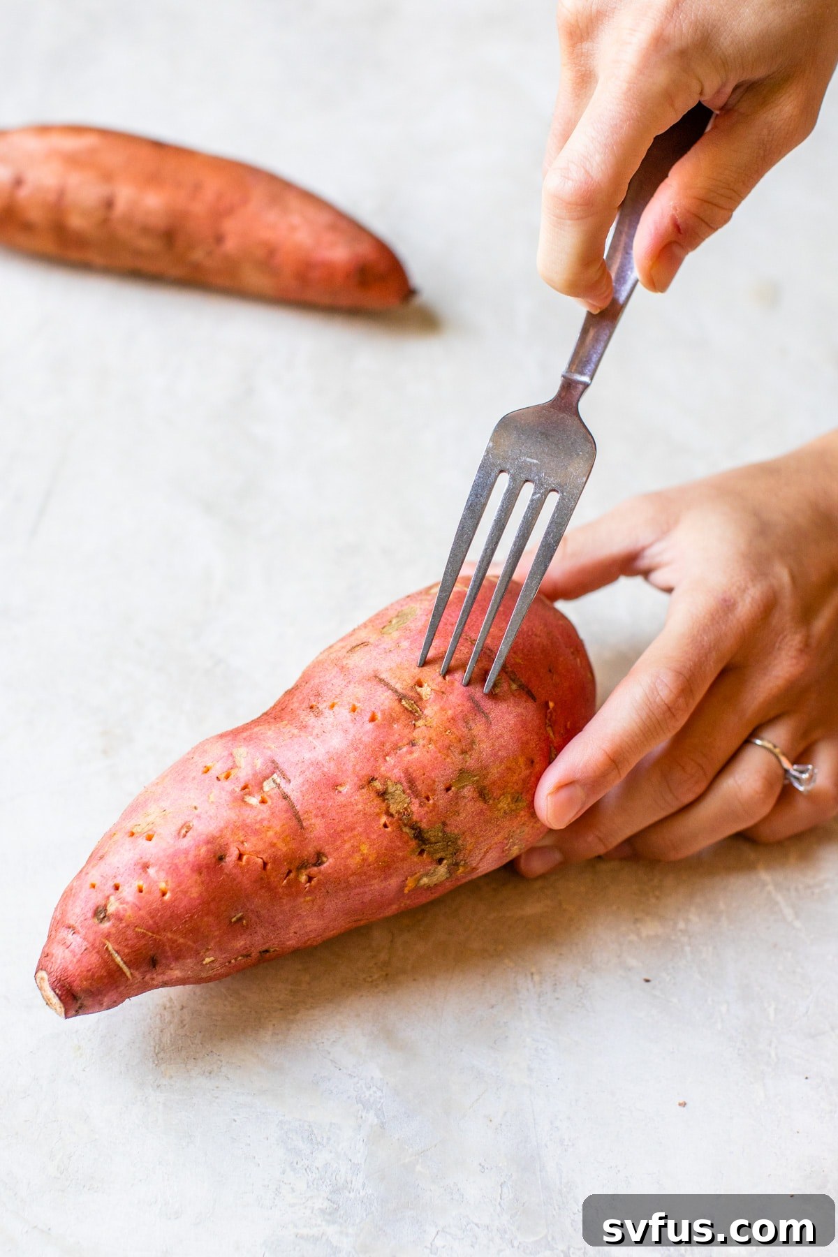 someone poking holes in a sweet potato with a fork