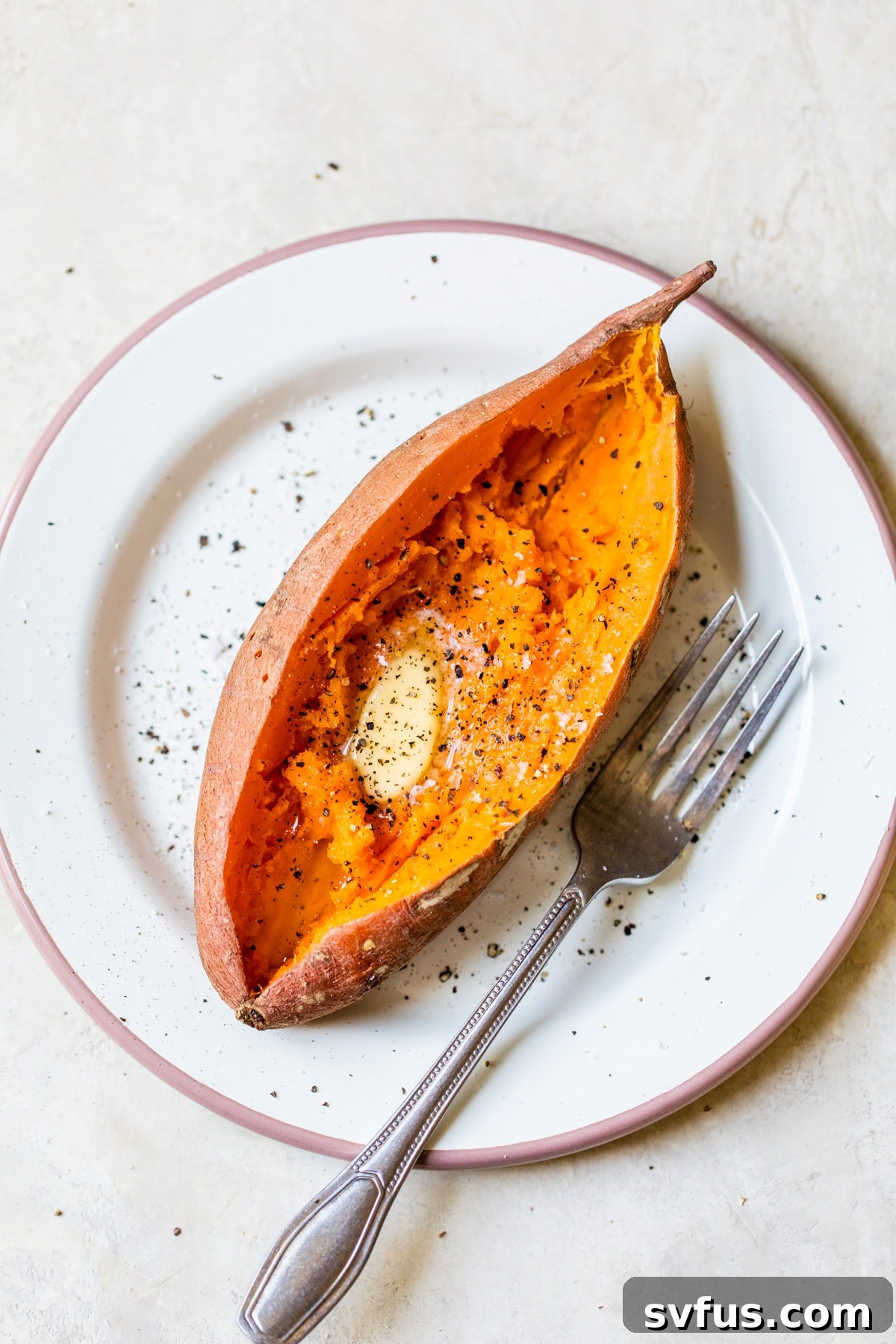 cooked sweet potato with melted butter on a plate, ready to eat
