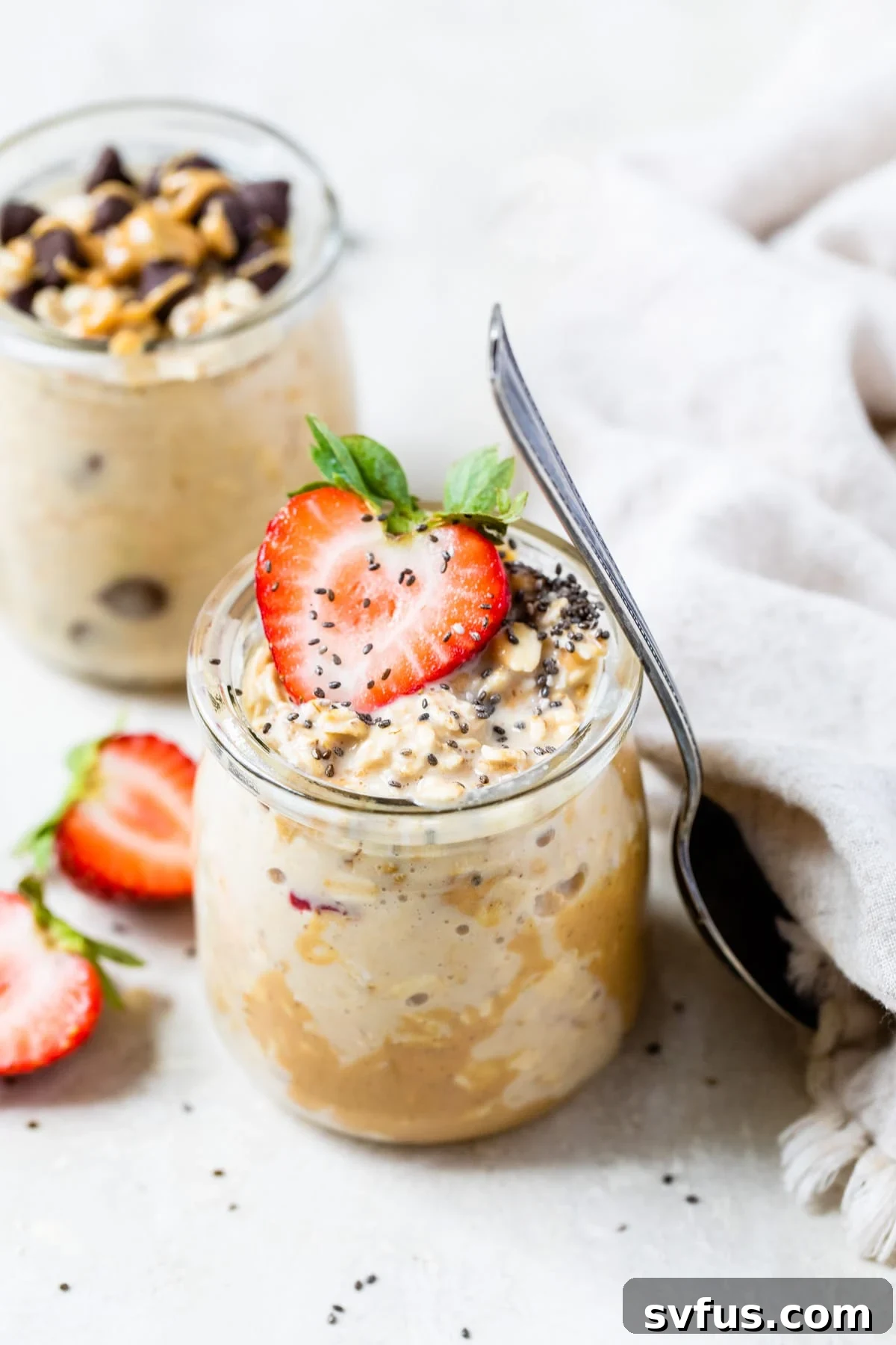A jar of protein overnight oats topped with creamy peanut butter and fresh strawberries, a perfect healthy breakfast.