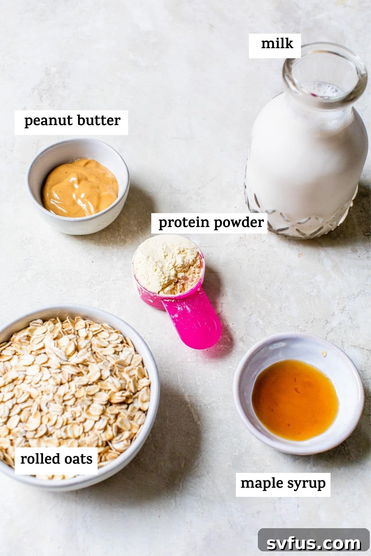 Ingredients for protein overnight oats laid out, including oats, peanut butter, maple syrup, protein powder, and milk.