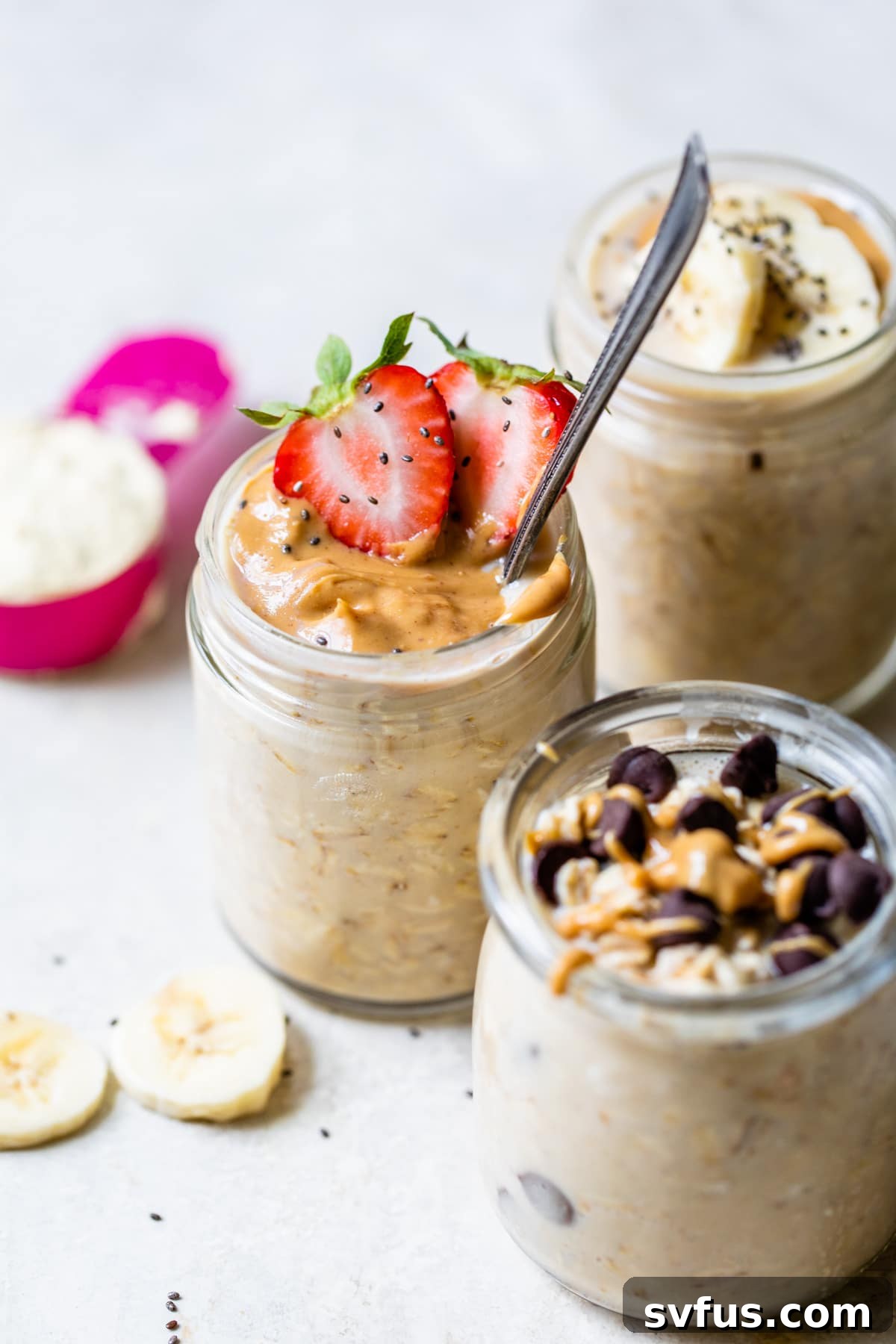 A beautiful jar of peanut butter protein overnight oats, generously topped with creamy peanut butter and fresh strawberries, ready to eat.