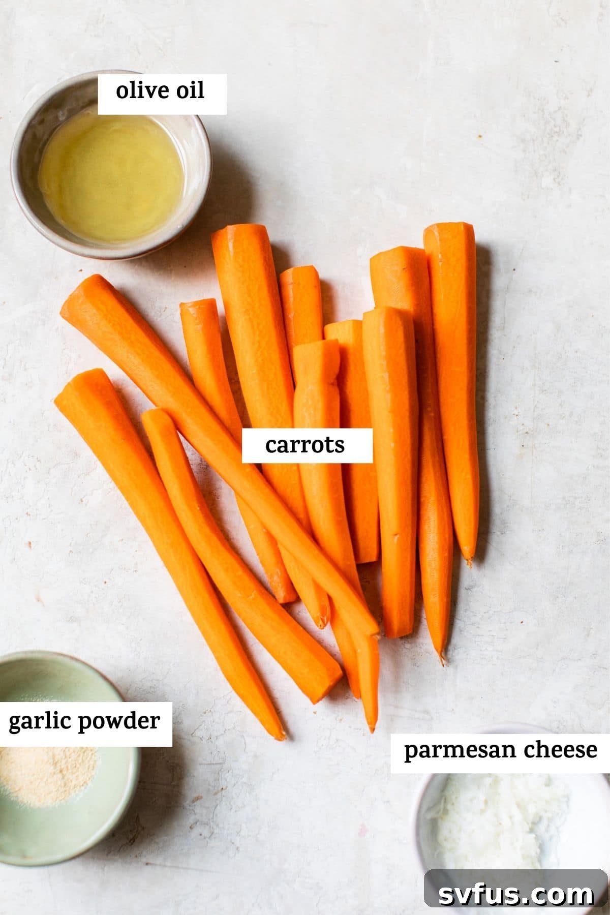 Close-up of fresh carrots, olive oil, garlic powder, and parmesan cheese on a wooden board, ready for air frying.