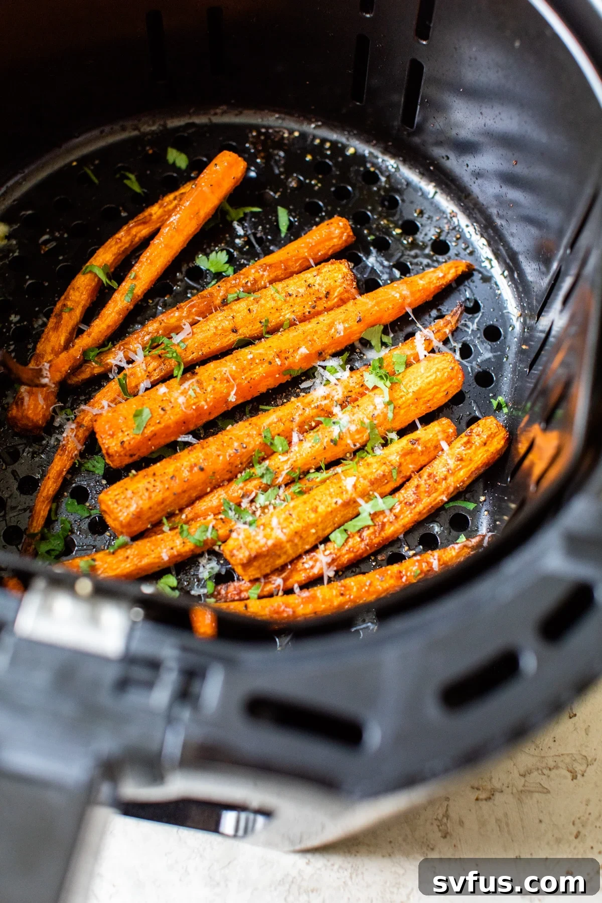 Golden-brown air fryer carrots cooked to perfection in the air fryer basket.