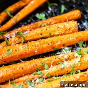 Crispy air fryer carrots topped with fresh parmesan cheese and chopped parsley, ready to serve.