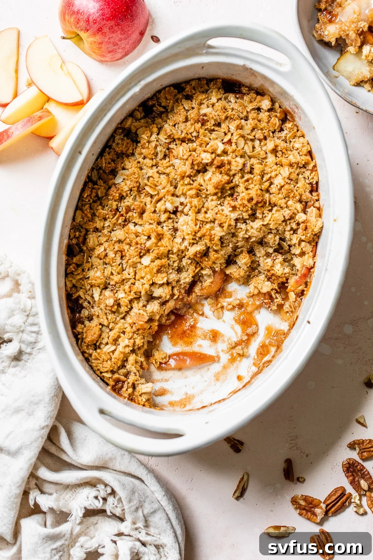 A large oval casserole dish filled with a beautifully baked gluten-free apple crisp, ready to be served.