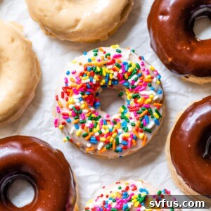 Freshly baked vegan donuts cooling on parchment paper.