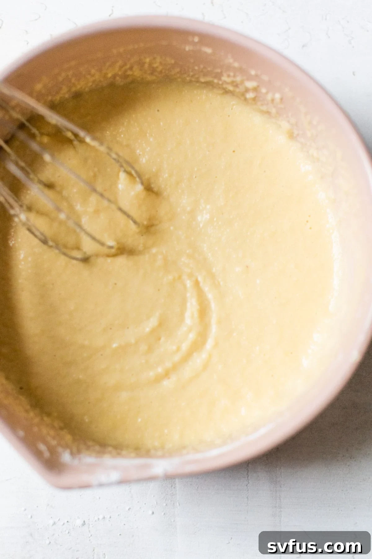 Smooth, runny paleo waffle batter in a mixing bowl, ready to be poured into the waffle iron.