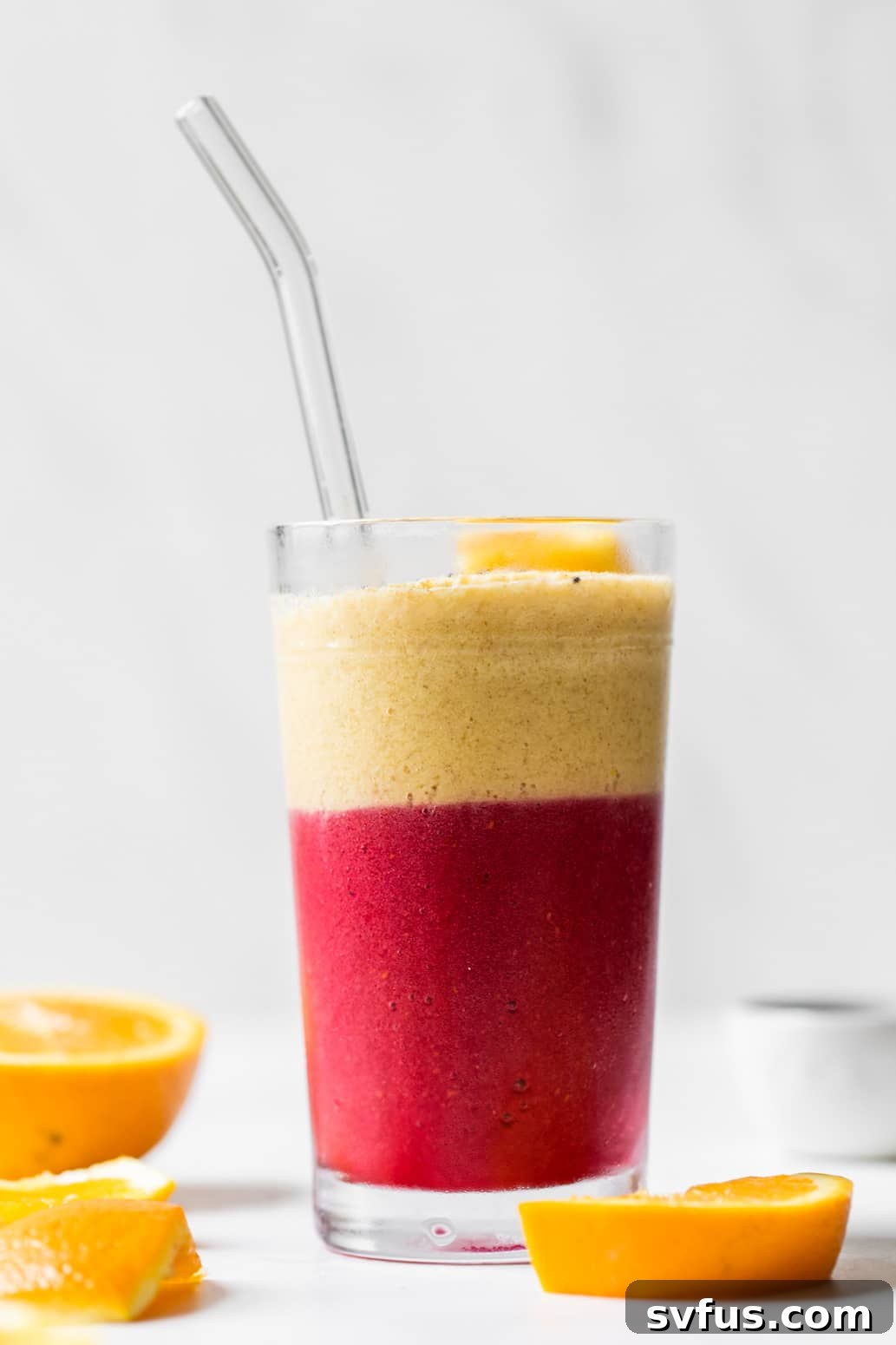 layered pink and orange smoothie in a glass, showcasing a non-layered option as well
