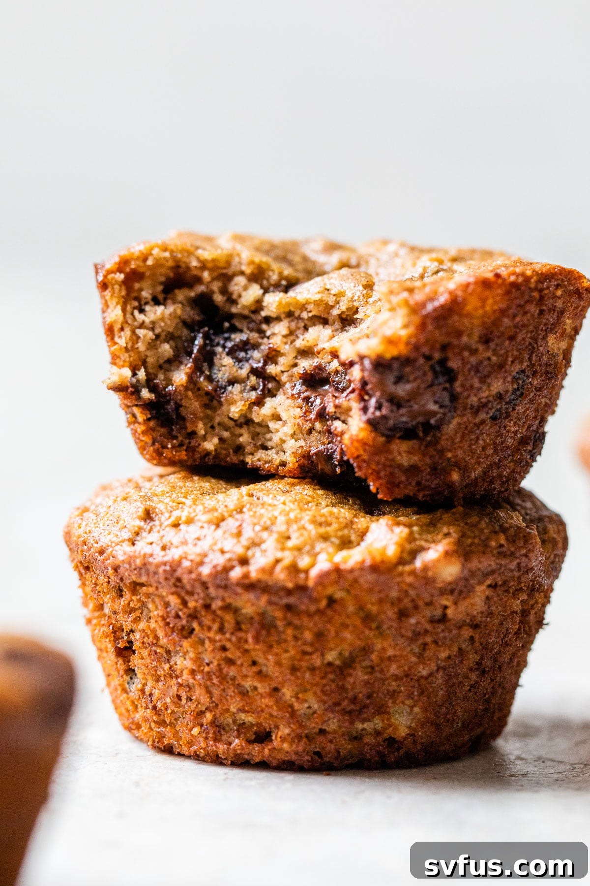 A close-up shot of an almond flour banana muffin with a bite taken out, showing the tender crumb.