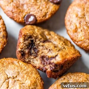 A delicious almond flour banana chocolate chip muffin with a bite taken out, showcasing its moist texture and chocolate chunks.