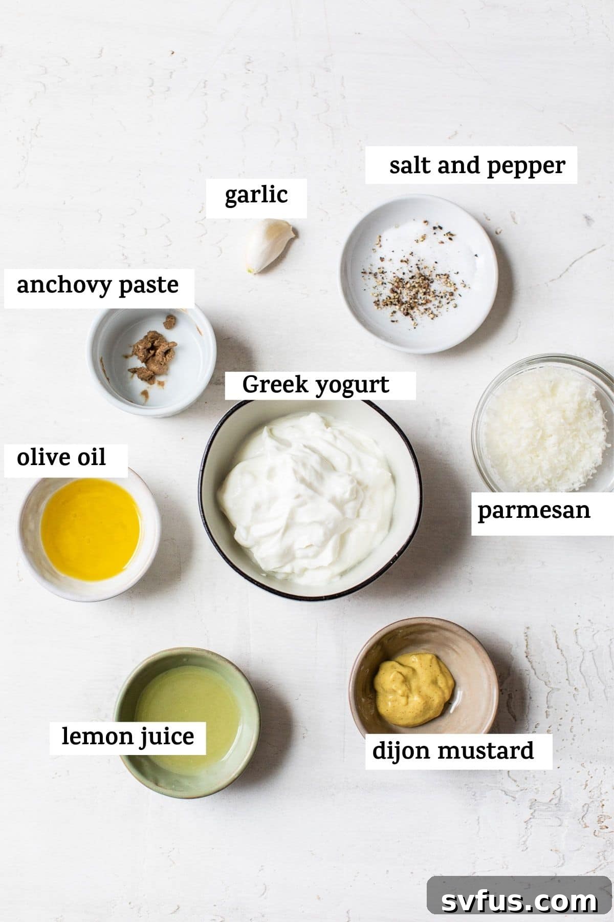 Ingredients for caesar dressing in small ramekins on a table