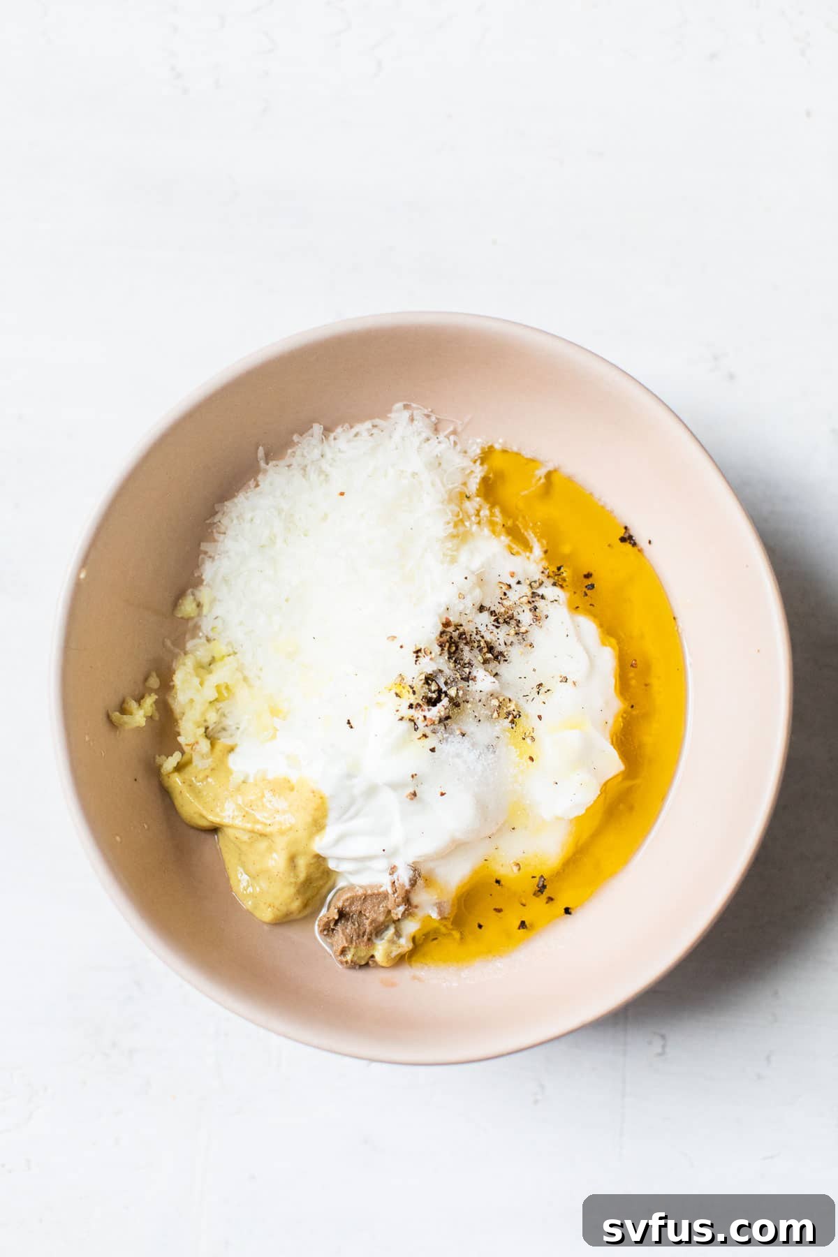 Caesar salad dressing ingredients in a bowl