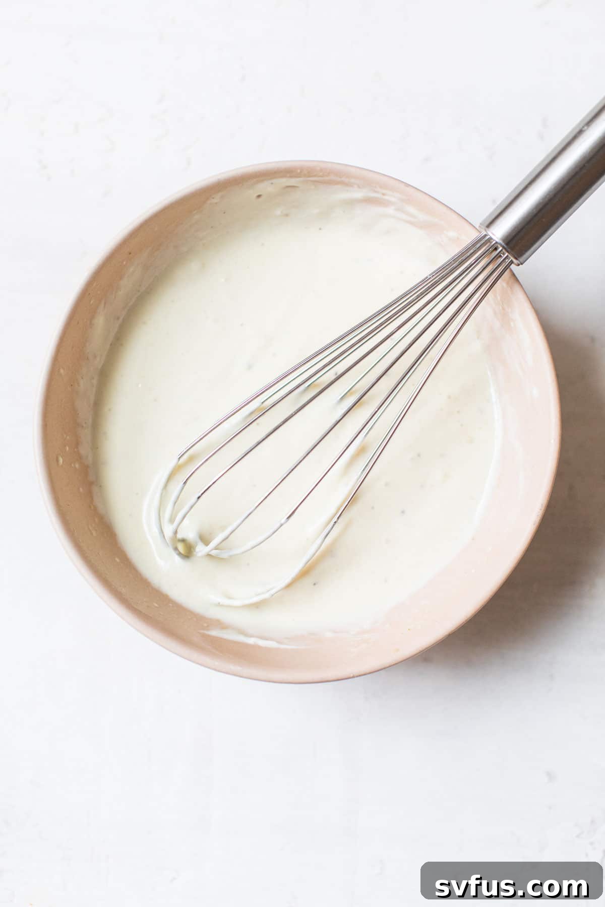 Whisked Caesar dressing ingredients in a mixing bowl