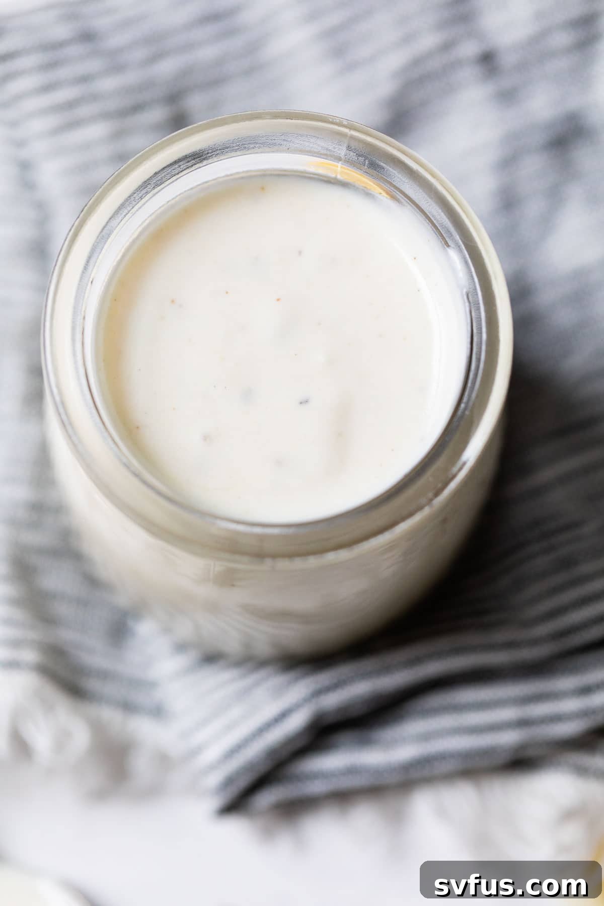 Close up photo of homemade Caesar salad dressing in a jar