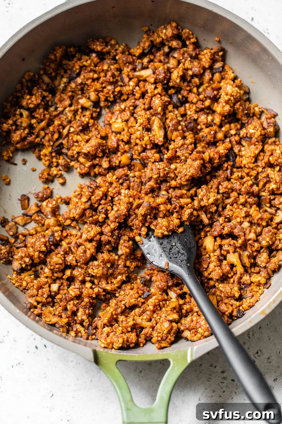Blended seasoned walnuts and mushrooms in a skillet, ready to be served as delicious vegan taco meat.