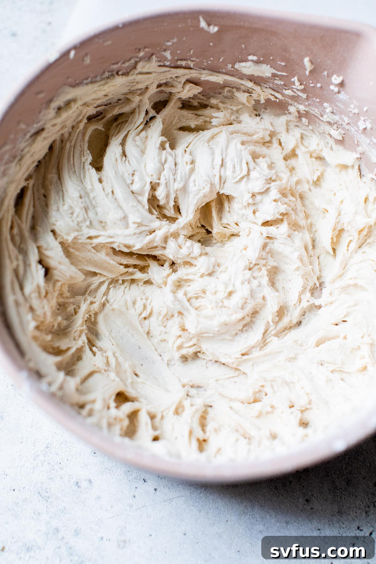 A bowl of light, fluffy vegan cinnamon buttercream, ready for frosting.
