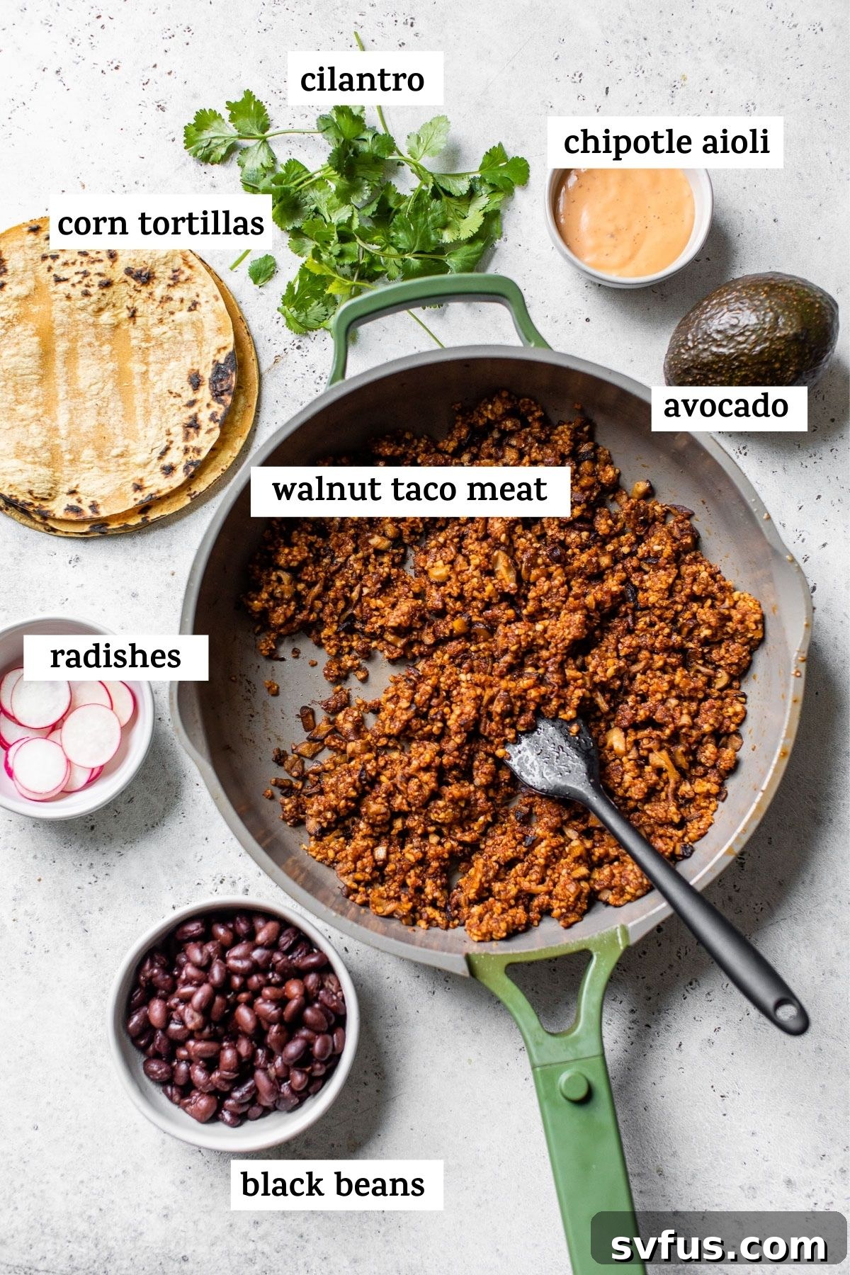Overhead shot of fresh taco ingredients neatly arranged on a table, including walnut taco meat, sliced radishes, avocado, and black beans, ready for assembly.