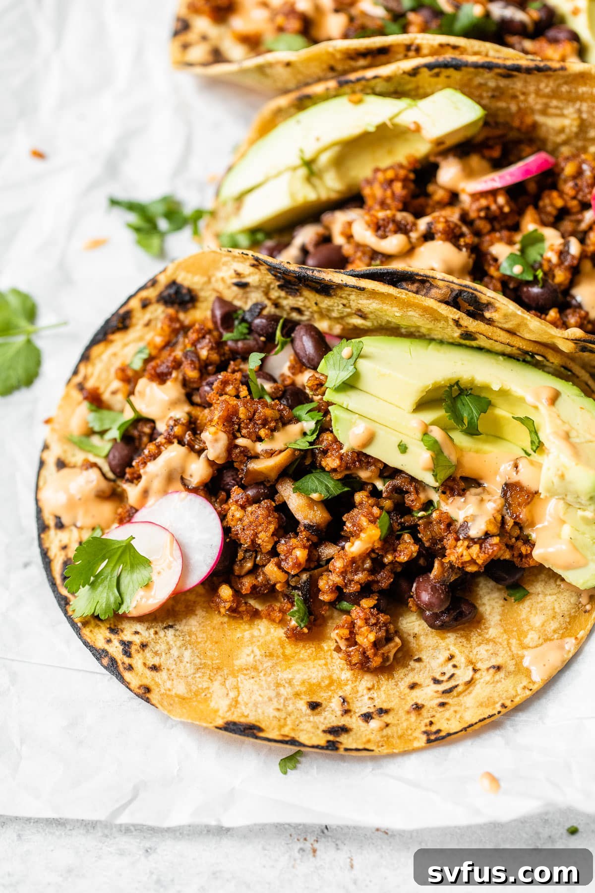 Close-up shot of a single vegan walnut taco, bursting with flavorful walnut taco meat and creamy avocado, ready for a delicious bite.