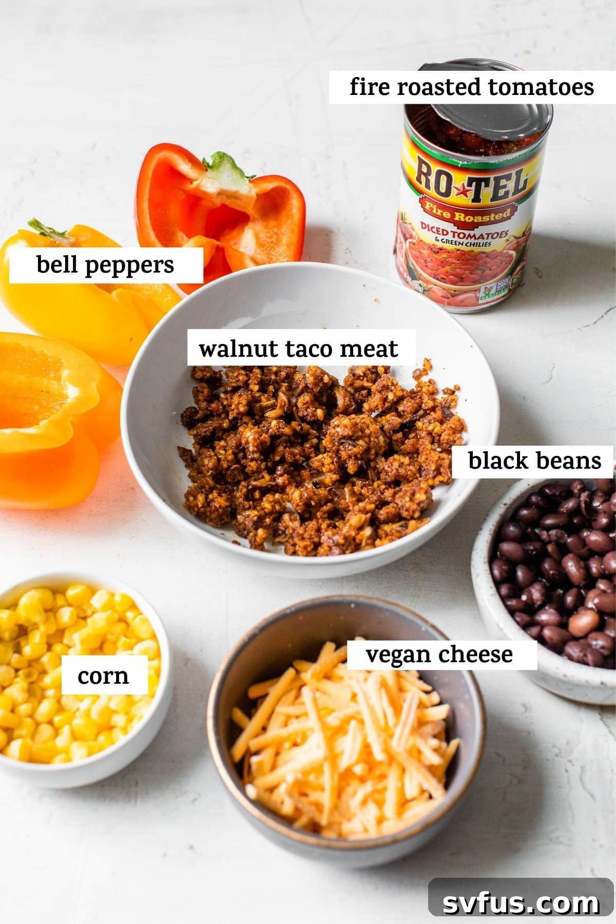A selection of fresh ingredients including bell peppers, walnuts, beans, and corn laid out on a table, ready for cooking.