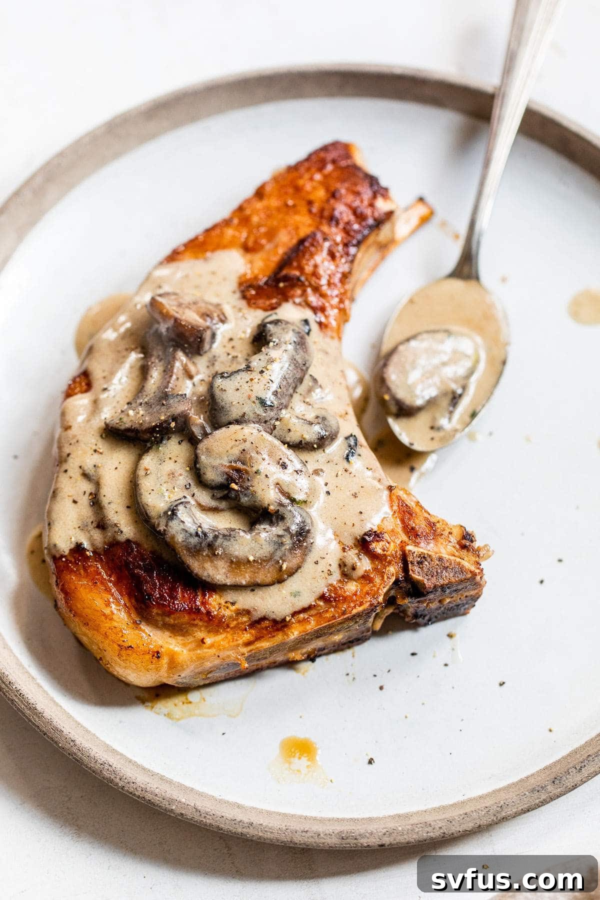bone-in porch chop on a plate with mushroom sauce
