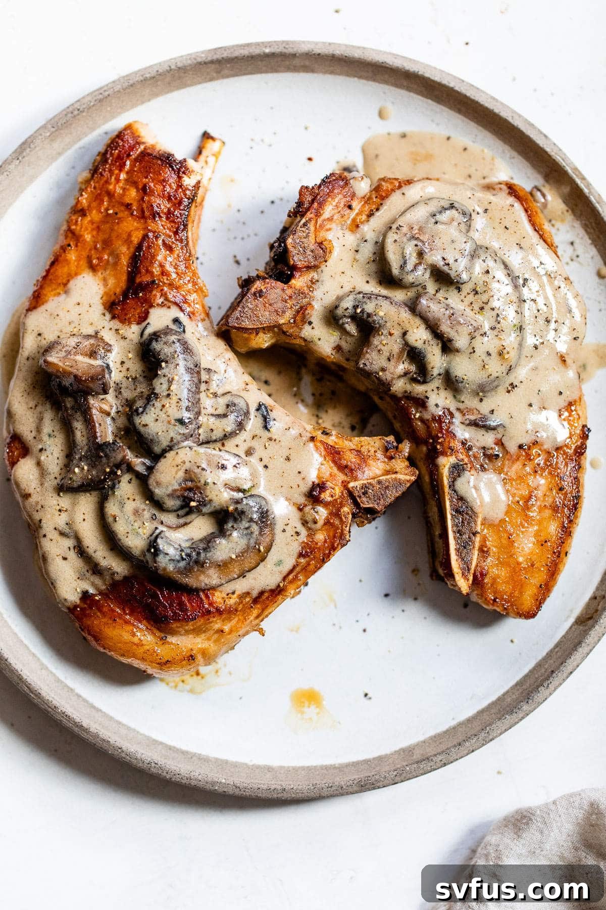 two cooked pork chops on a plate