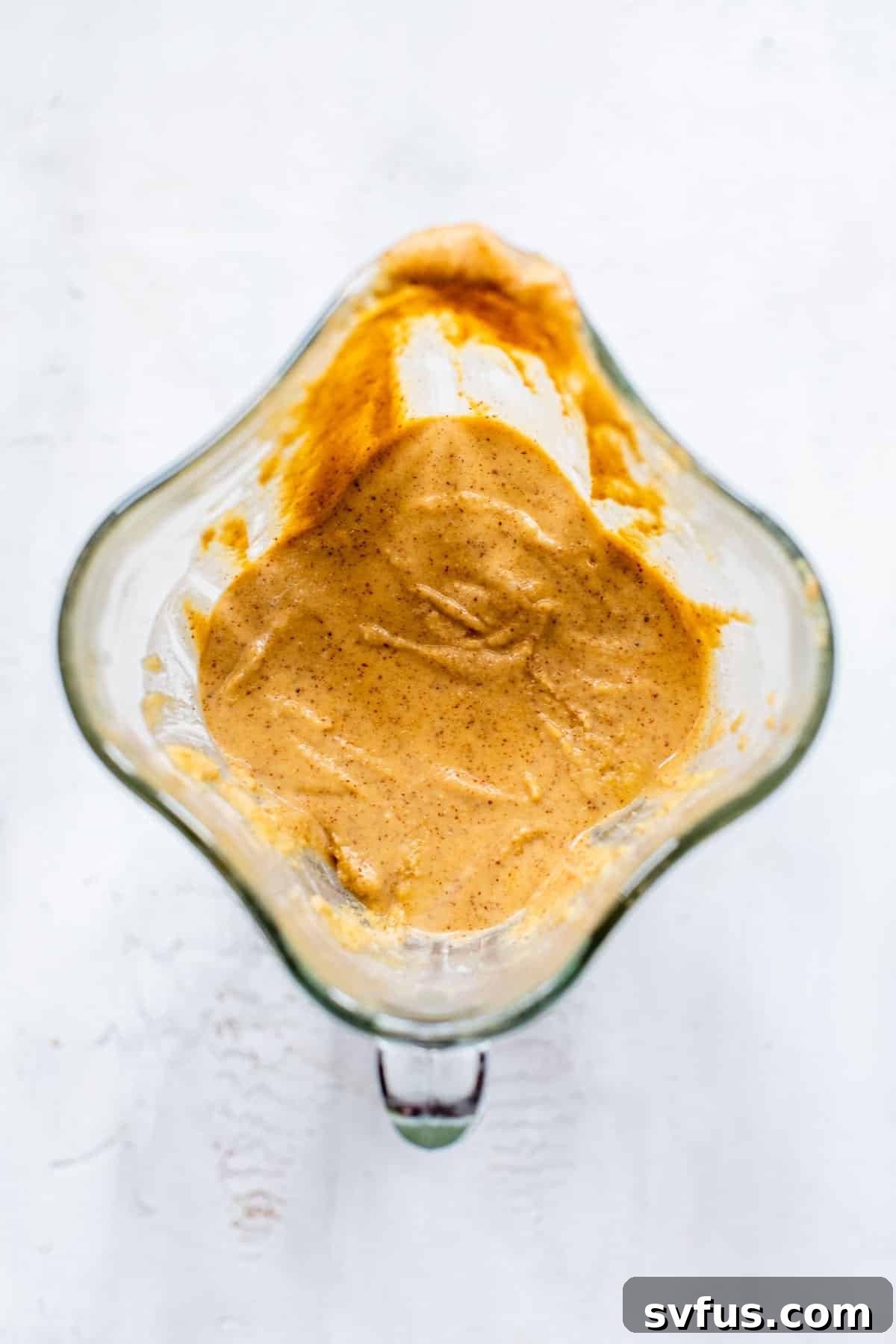 Smooth, thick muffin batter swirling in a high-power blender, ready for chocolate chips.