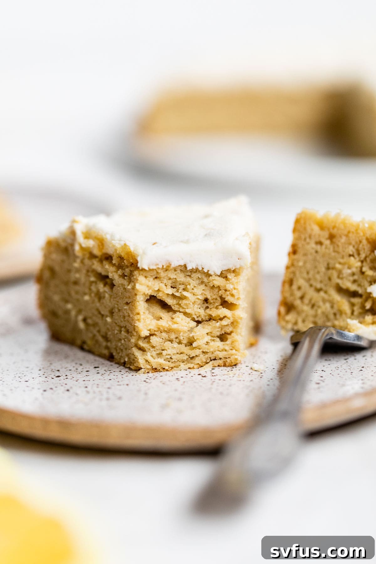 A delectable slice of Coconut Flour Cake, with a perfect bite taken out, resting on a plate, highlighting its moist interior and tempting texture.