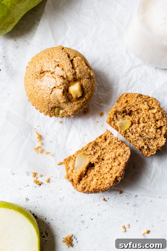 A pear muffin cut in half, revealing its tender, fruit-filled interior, ready to be enjoyed.