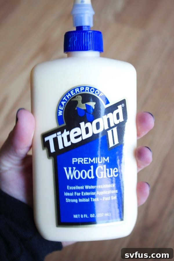 Applying wood glue into the groove of a wooden plank