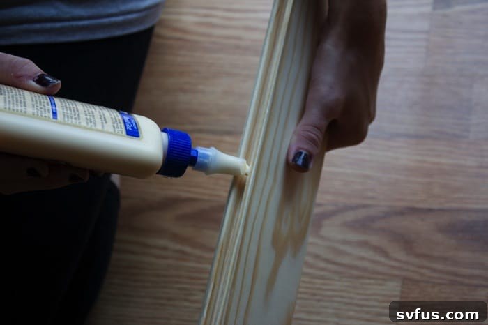 Two wooden planks being joined together with wood glue
