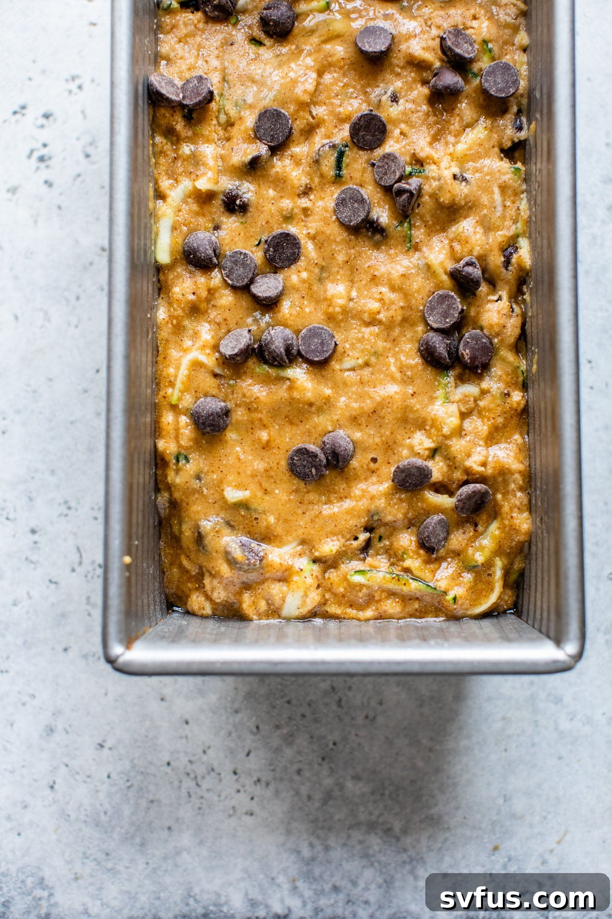 Zucchini bread batter with chocolate chips in a bread pan