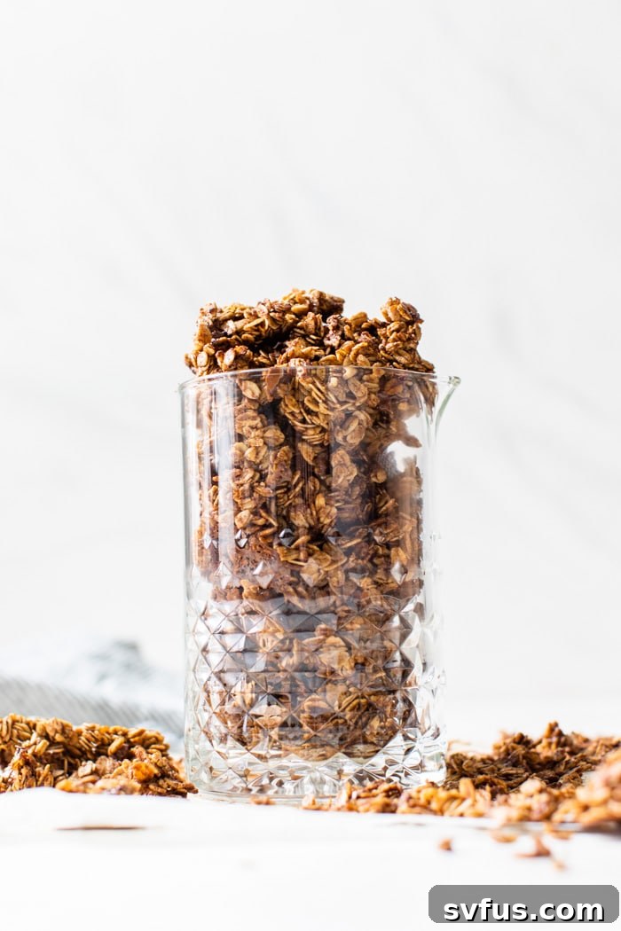 Homemade gingerbread granola stored in a rustic glass jar, illustrating ideal storage for freshness.