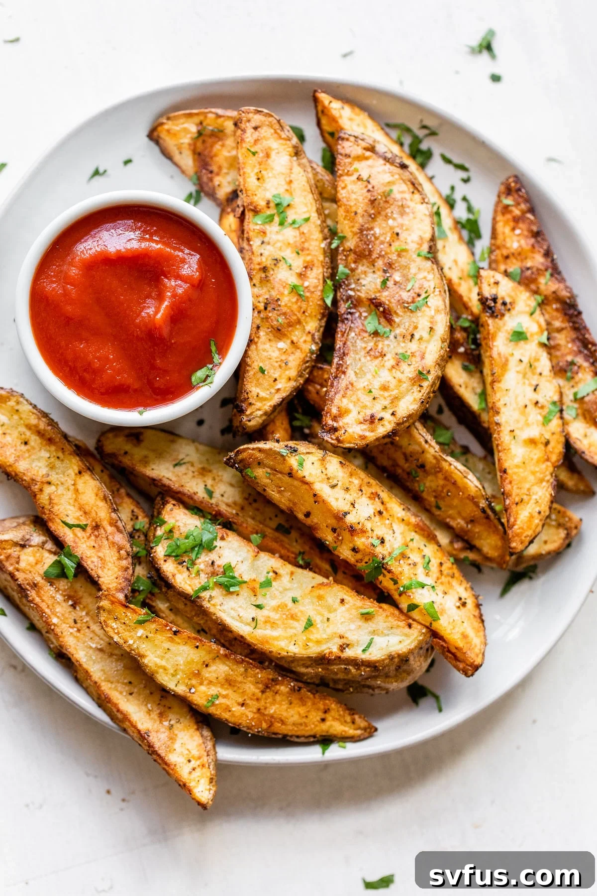 cooked potato wedges on a plate with a side of ketchup
