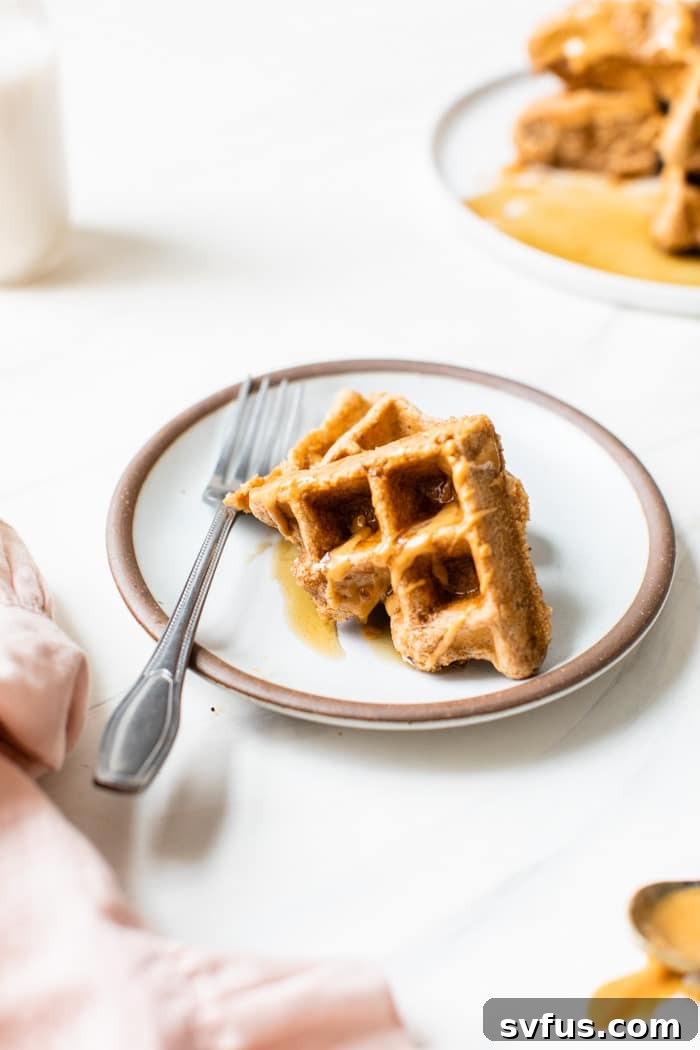 Close-up of a single peanut butter waffle on a white plate, ready to be topped