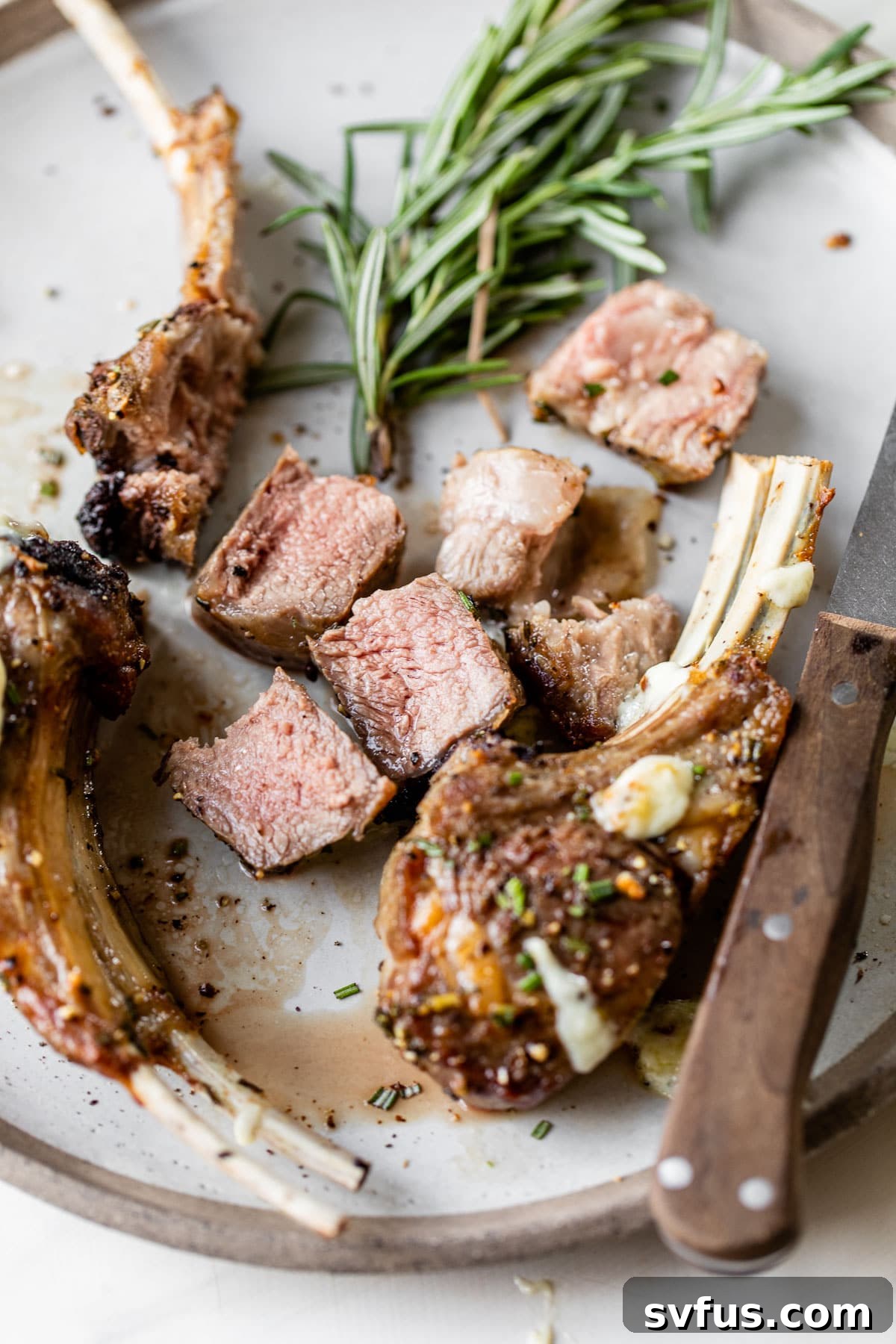 Close-up of chopped cooked lamb meat on a white plate, showcasing its tender texture.