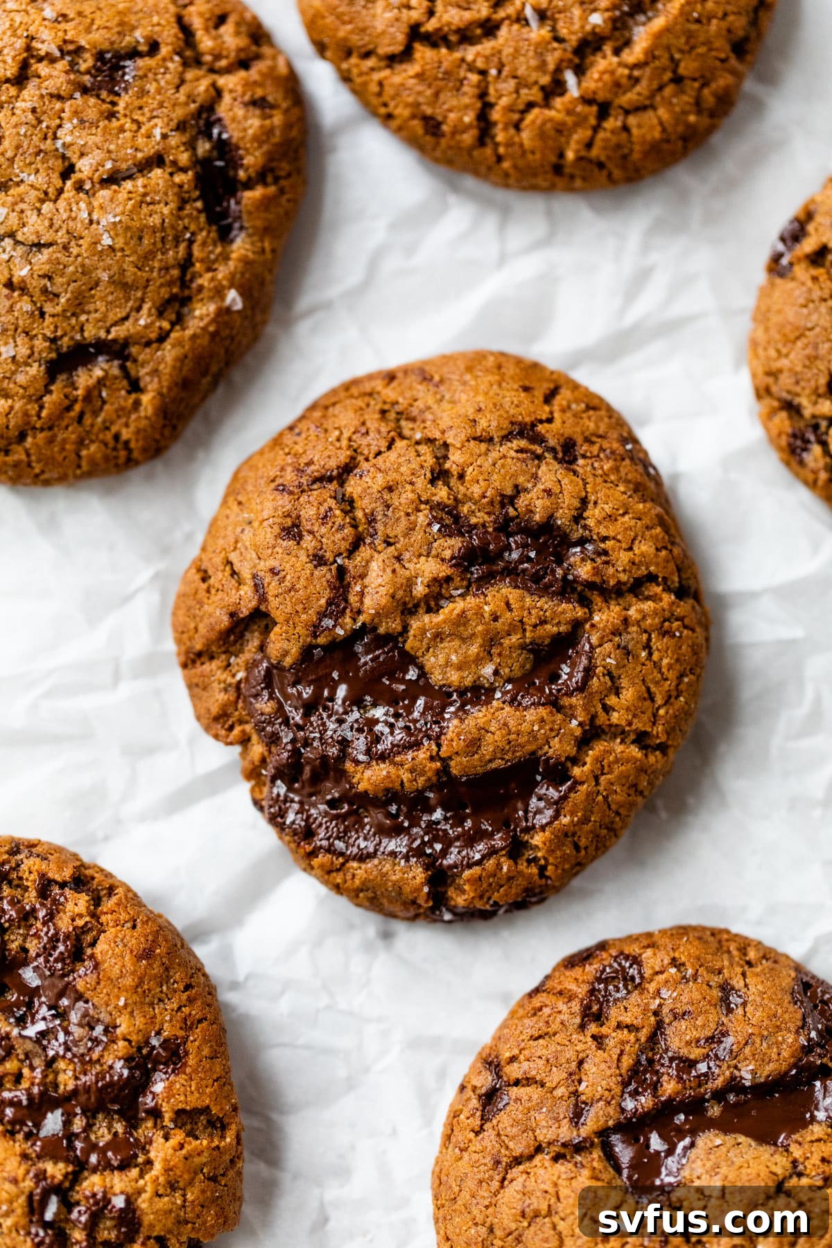 Close-up of freshly baked flourless chocolate chip cookies on a cooling rack, showing their appealing texture.