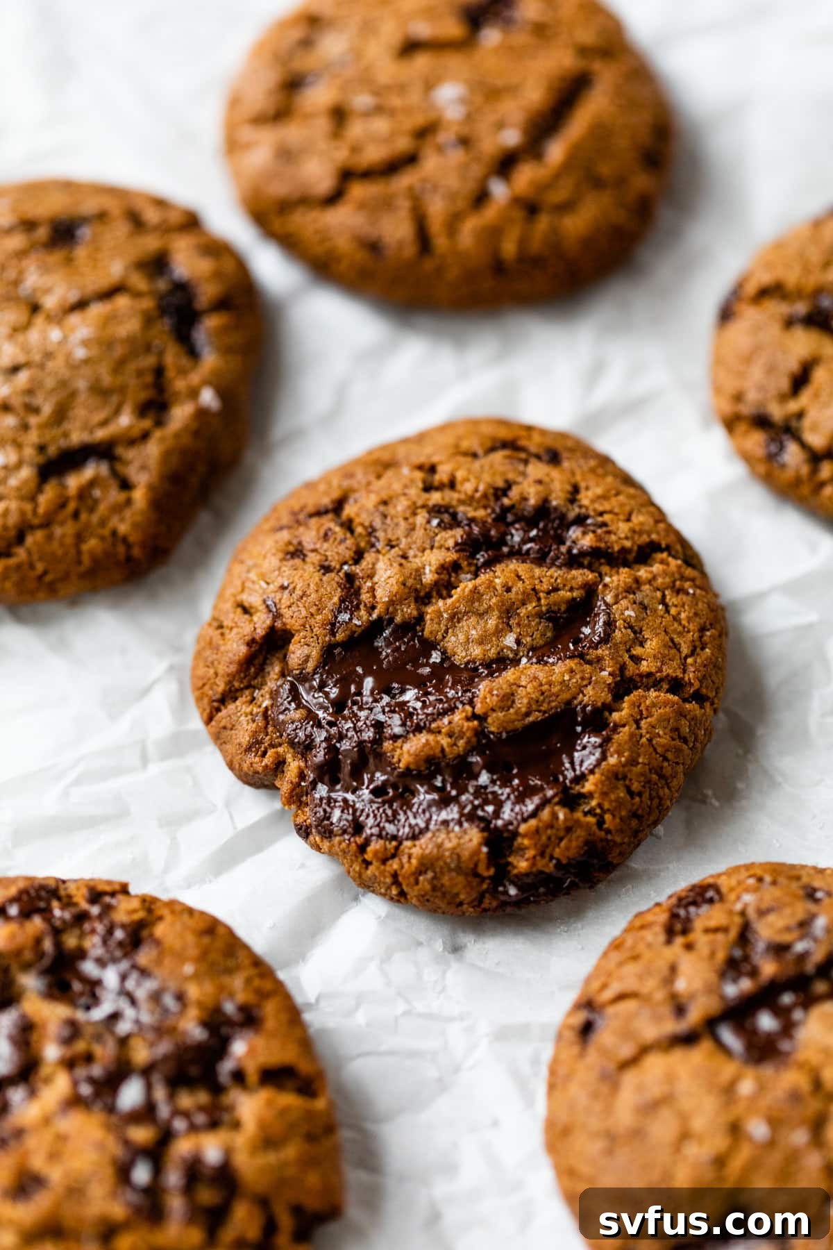 Close-up of flourless chocolate chip cookies stacked on a cooling rack, showcasing their rich color and texture.